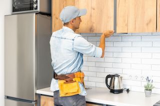 Foto: Handwerker baut Küchenschrank ein